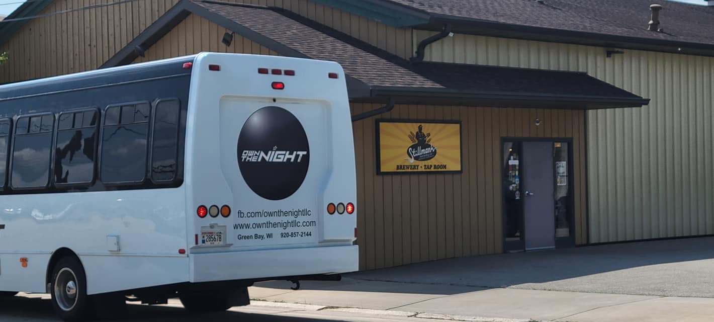 Rear of the bus with the Own The Night logo.
