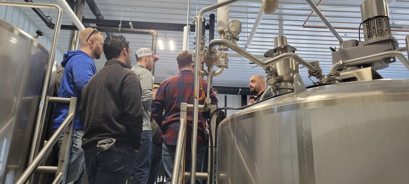 Guests gathered around the brewing tanks during a tour.