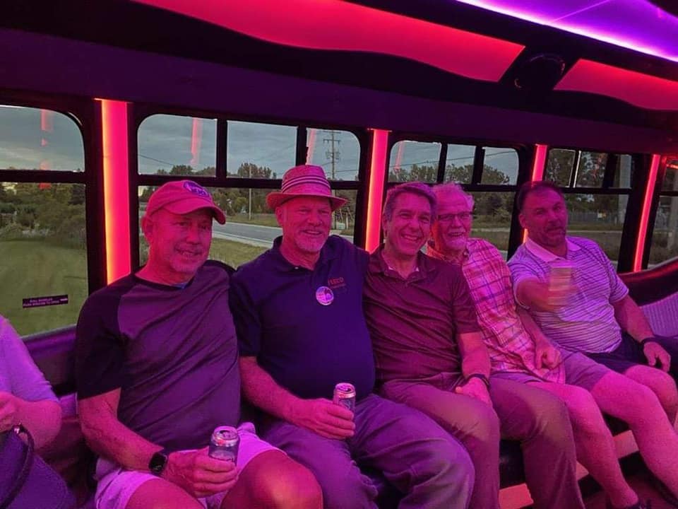 Friends riding the bus at dusk with the cabin lights on.